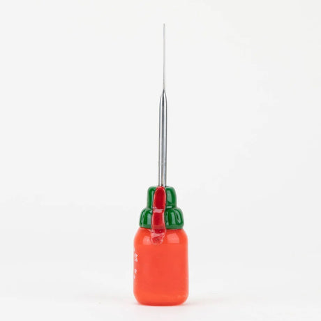 Rear side view of Sriracha dabber displaying green cap, attached red chili accent, and long metal scoop handle against white studio background.