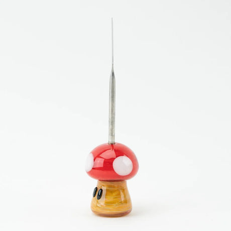Side profile of mushroom dabber showing tapered stainless scoop and full red-and-yellow glass body, photographed on white background.