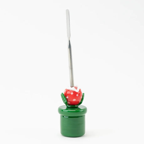Side profile of piranha-plant dab tool highlighting pipe-style base, leafy arms, and thin stainless scoop against white studio background.