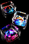 Square glass ashtray trio with neon wolf, fox, and cat illustrations glowing on reflective black surface.