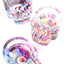 Skull glass ashtray set with psychedelic splatter and eyeball graphics, iridescent hues, deep circular bowl and front grooves on white backdrop.