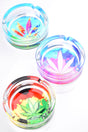 Round 4-inch glass ashtrays sporting pastel cannabis leaf graphics in aqua, purple and rasta gradients; deep bowl, three grooves, studio overhead lighting.