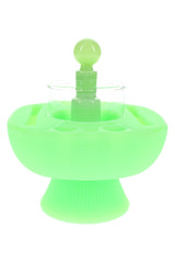 Glow green Hemper IsoPlex dab cleaning station with clear glass reservoir and round glass carb cap centered on a pedestal base.