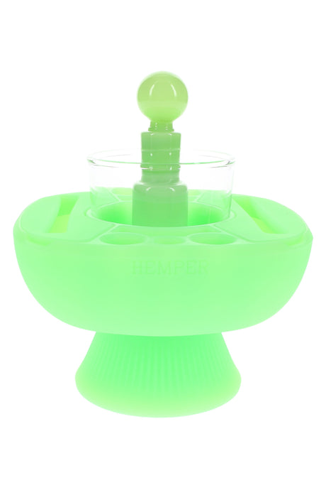 Glow green Hemper IsoPlex dab cleaning station with clear glass reservoir and round glass carb cap centered on a pedestal base.
