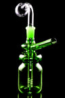 Green bottle-shaped mini oil burner rig with donut neck accents and angled straw mouthpiece, black background.