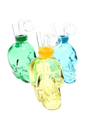 US-made thick glass skull oil burner rig with bent mouthpiece and fixed globe burner, assorted translucent colors on white background.