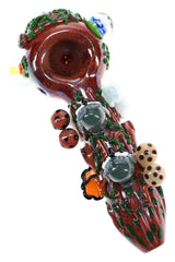 Empire Glassworks glass hand pipe with log-brown body, green vines, gray owls, and mushroom accents