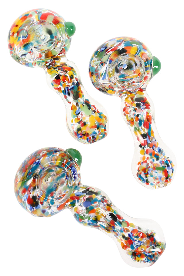 Clear 3.5-inch borosilicate spoon pipe filled with vibrant multicolor confetti frit, deep bowl and side carb visible on white backdrop.