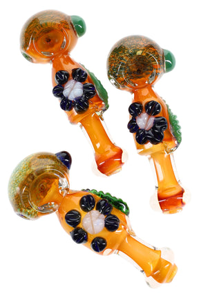 5″ gold-fumed frit glass spoon pipe with raised flower and leaf accents, side carb, and rounded mouthpiece; warm amber color; sold individually.