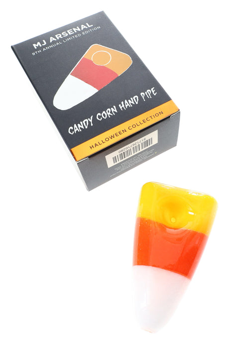 MJ Arsenal Candy Corn hand pipe beside Halloween Collection box, thick borosilicate glass in festive tri-color design for dry herb.