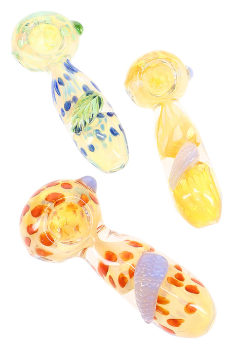4 inch fumed color changing polka dot glass hand pipe with leaf accent, shown in assorted spoons with blue and orange spots