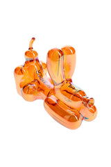 Hemper 4″ Balloon Dog amber glass pipe in lounging pose, bowl on the belly and nose mouthpiece against white background.