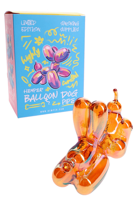 Hemper Balloon Dog 4″ amber glass hand pipe beside bright blue box with bold balloon dog artwork for shelf-ready display.