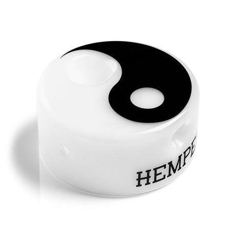 Close-up of Hemper Yin Yang glass hand pipe showing opaque white body, carb hole, and crisp yin-yang top
