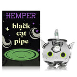Hemper Black Cat glass hand pipe next to branded box, front view with cat face decal on cauldron bowl