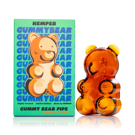 Hemper gummy bear hand pipe beside retail box, side profile showing rounded grip-friendly body for dry herb use