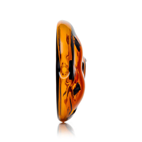 Side profile of amber cookie-shaped glass hand pipe highlighting thickness, curved mouthpiece, and chip accents