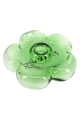 Top-angle close-up of transparent green flower-shaped glass hand pipe showing petal contours and centered bowl area