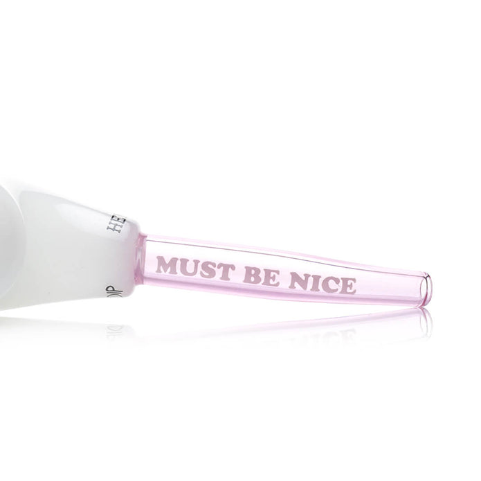 Close-up of pink-tinted mouthpiece showing “MUST BE NICE” text detail on RIPNDIP x Hemper glass hand pipe