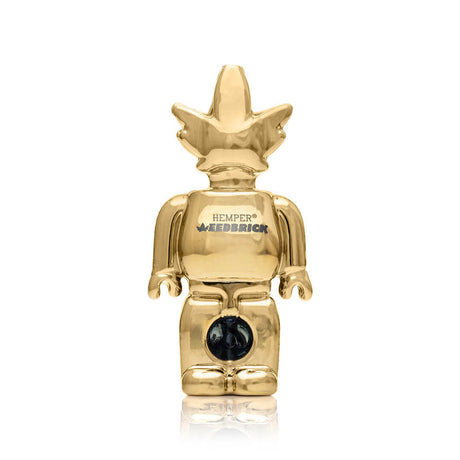 Centered front shot of gold Weedbrick glass hand pipe showing block-figure silhouette and glossy mirror finish