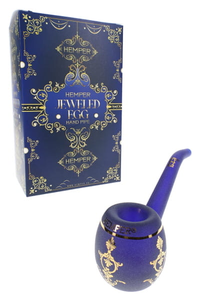 Metallic blue 5-inch glass hand pipe shaped like a jeweled egg with ornate gold-style accents on display