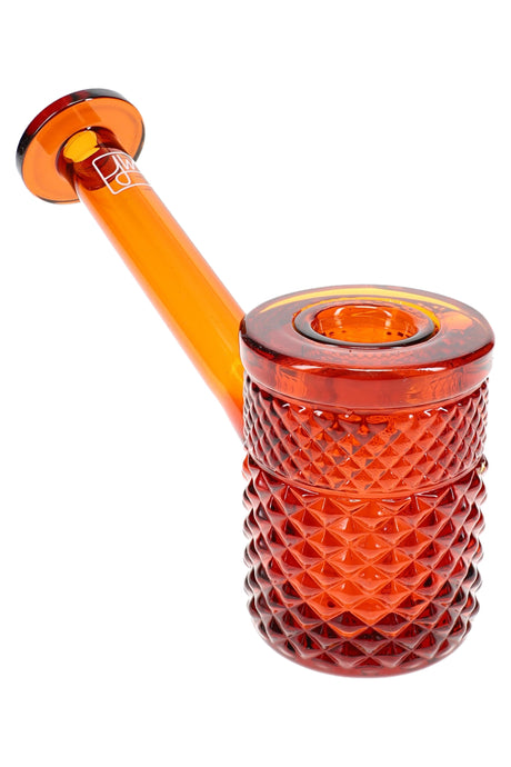 Amber Jane West glass hand pipe with warm orange body, textured bowl, and flat tabletop base