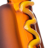 Macro view of BigFun! Glizzy hot dog glass hand pipe with raised yellow mustard winding along the amber body