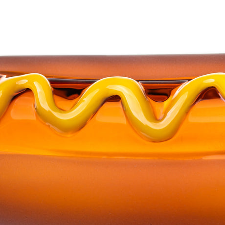 Close-up of BigFun! Glizzy hot dog hand pipe showing the glossy raised yellow mustard swirl over amber glass
