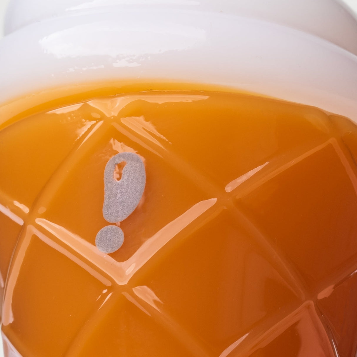 Close-up of logo mark and raised waffle cone texture on orange ice cream glass hand pipe body