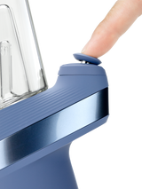 Puffco Peak Sapphire e-rig close-up showing finger pressing the blue Joystick Cap