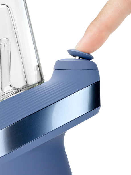 Puffco Peak Sapphire e-rig close-up showing finger pressing the blue Joystick Cap