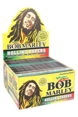 Countertop display box of Bob Marley king size hemp rolling papers showing 50 assorted booklets with bright yellow reggae artwork and “Pure Hemp” badge.