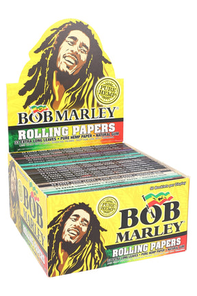 Countertop display box of Bob Marley king size hemp rolling papers showing 50 assorted booklets with bright yellow reggae artwork and “Pure Hemp” badge.