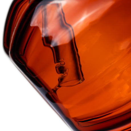 Close-up of MJ Arsenal pumpkin glass bubbler internal downstem and water-filtration chamber through orange glass