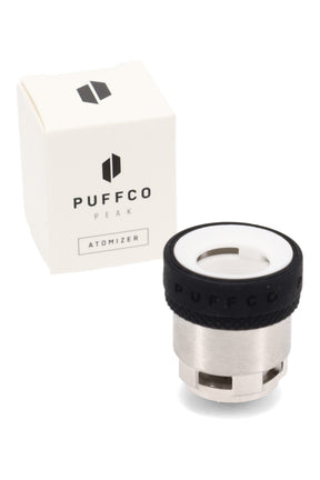 Puffco Peak replacement atomizer chamber with white ceramic bowl and black grip band, shown next to the Puffco retail box.