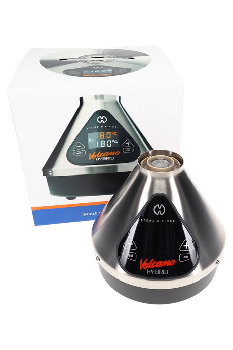 Storz & Bickel Volcano Hybrid desktop vaporizer with retail box, stainless finish, triangular touch display and top opening visible.