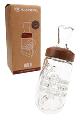 Halo Puffco Peak replacement glass by MJ Arsenal beside Alpine Collection box, clear can-shaped body with handle and wood ring accent.