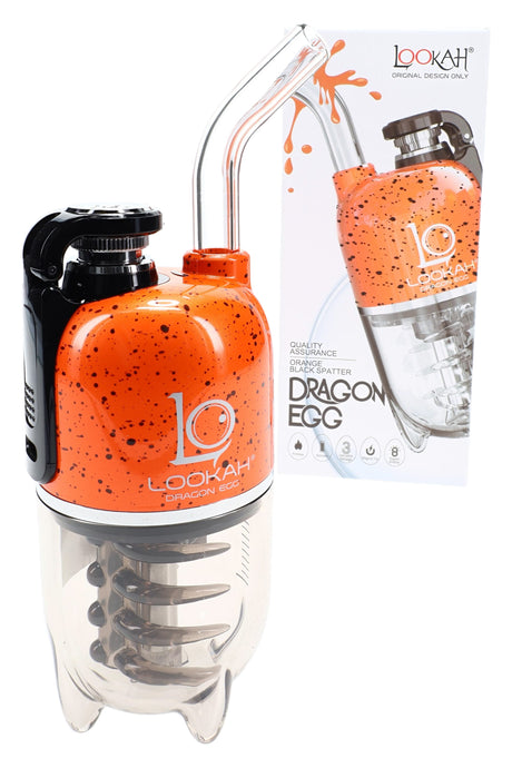 Lookah Dragon Egg electric dab rig in orange with black splatter, compact body and glass mouthpiece posed beside box.