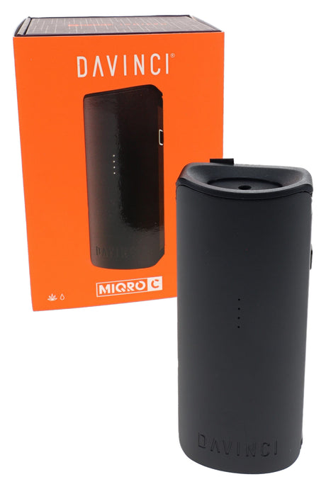 Compact black DaVinci MIQRO-C vaporizer with orange retail box, angled front view of portable dry herb vape