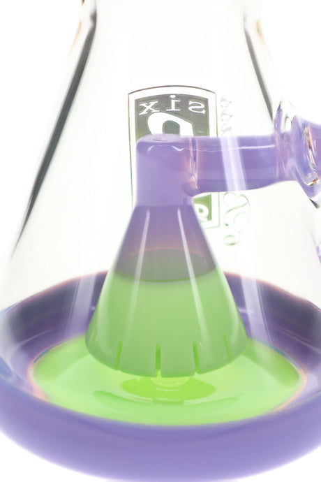 Close-up of purple and lime-green showerhead percolator inside a clear 6B Glass beaker bong.