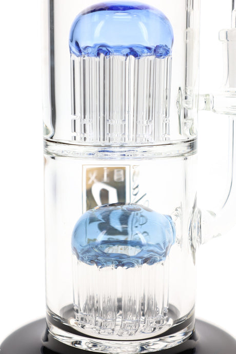 Close-up of two stacked tree percolators with blue dome tops and slotted clear glass arms inside a 6B Glass bong.
