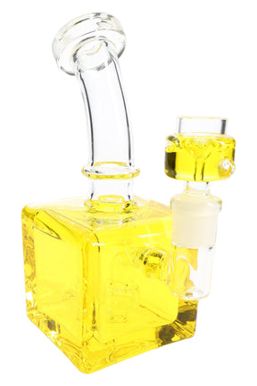 Yellow fluid-filled cube bong close-up with square chamber, curved neck, and glass bowl attachment.