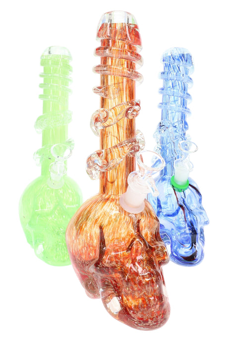 Soft glass skull bong trio in green, orange, and blue with spiral neck grips and sculpted skull bases; assorted colors; UV-reactive details.