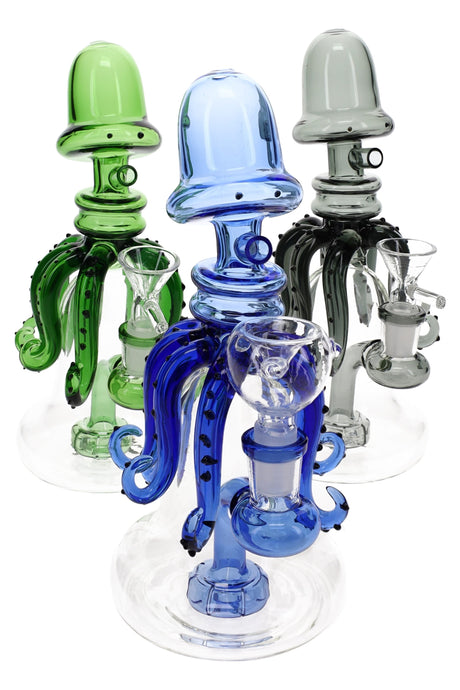 Trio of colorful glass squid bongs, 8.5″ tall with showerhead perc and 14.5 mm female joint on clear bases.