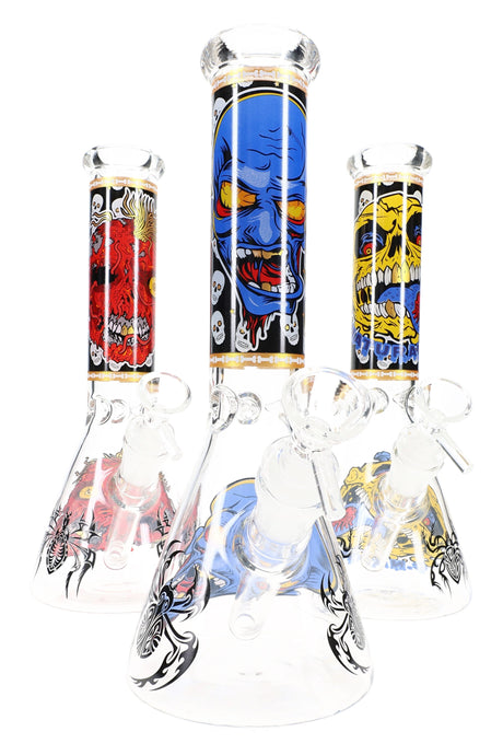 10″ glass skull-design beaker bong with ice pinch, 18.8 mm female joint and 14.5 mm bowl; three assorted graphic styles shown, sold individually.