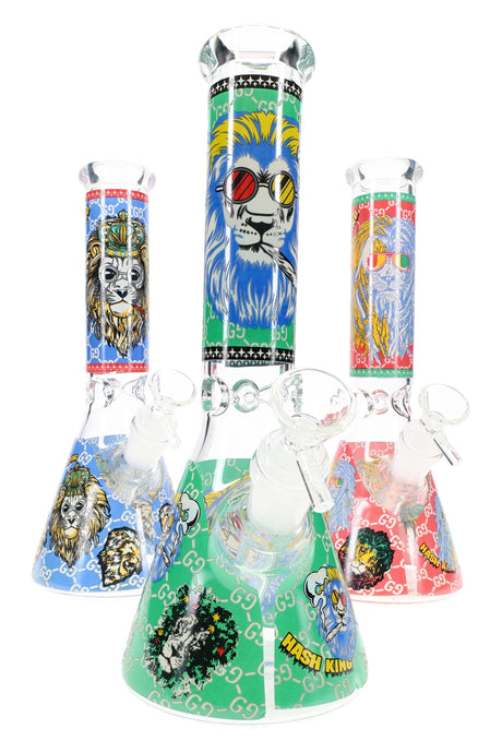 10″ glass beaker bong with glow-in-the-dark lion decals, ice pinch, 18.8 mm female joint and 14.5 mm bowl; three assorted designs shown, sold individually.