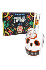 Hemper Dia De Los Muertos 6″ skull glass bong standing beside its colorful festival-print box, angled view for retail display.