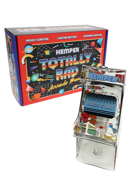 Hemper Totally Rad arcade glass bong posed beside its colorful branded box, showing mini cabinet shape and joystick herb bowl.