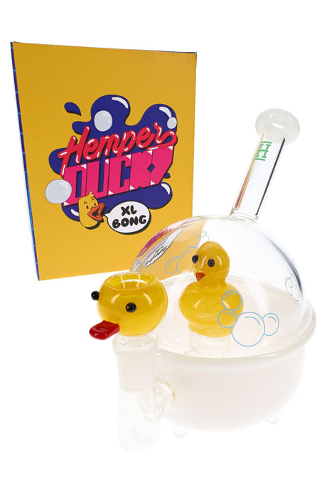 Hemper Ducky XL 8-inch glass bong shaped like a white bathtub with clear dome and yellow duck perc beside bright yellow box.