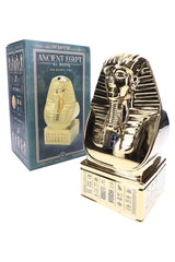 Side angle of Hemper Ancient Egypt XL gold pharaoh bong standing beside teal themed box, showing sculpted details and tall rectangular base.